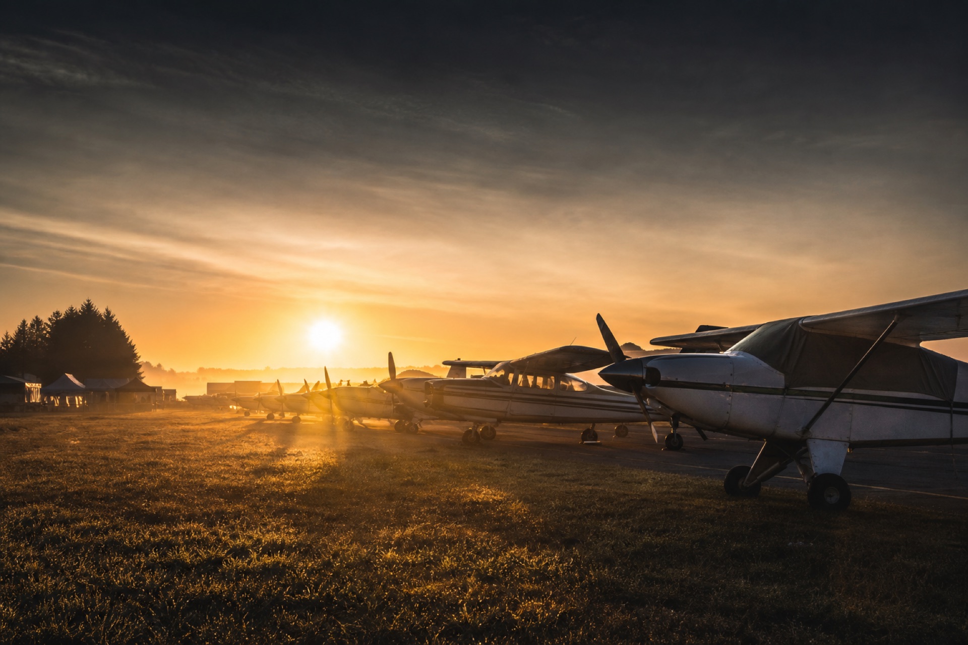 Hill Flights Events page — fly-in aircraft line in golden sunrise haze